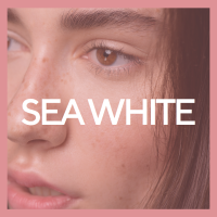 A soft Pink background with  the words sea white across a close up of a younger woman with hyperpigmentation 
